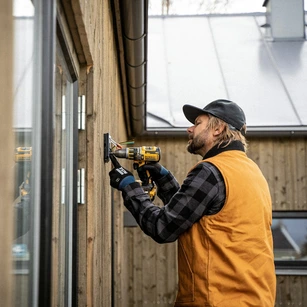 Tradesperson installing an electrical fixture on a property in Somerset or Dorset